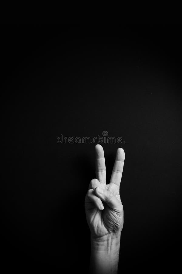 B&W image of hand demonstrating ASL sign language letter V with empty copy space stock photo