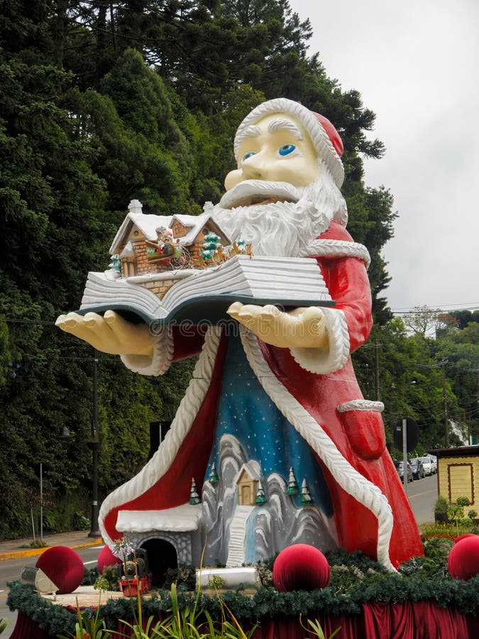 Babbo Natale regge un libro con bellissime decorazioni natalizie in Gramado Serra Gaucha Rio Grande do Sul Brasile immagine stock libera da diritti