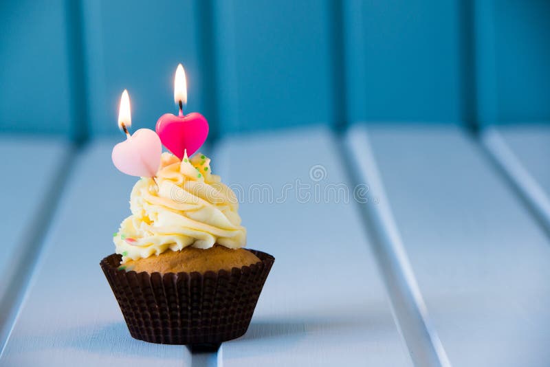 Birthday's cake - cupcake with a heart shaped candles for 2 - second birthday or valentine's day. Birthday's cake - cupcake with a heart shaped candles for 2 - second birthday or valentine's day.