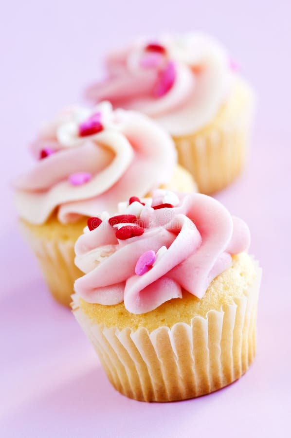 Row of tasty cupcakes with icing and sprinkles. Row of tasty cupcakes with icing and sprinkles