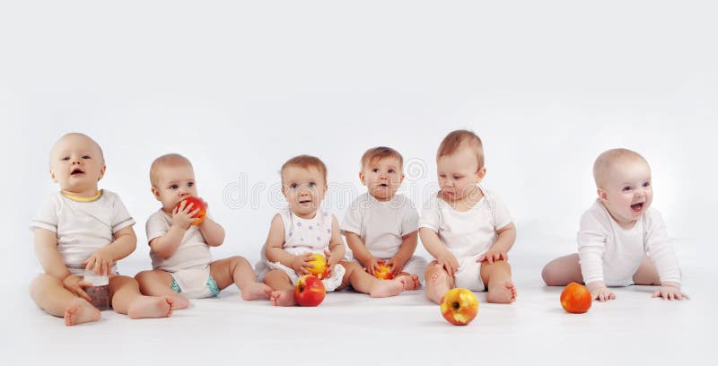 Gruppo di bambini con le mele seduto su bianco studio di sfondo.