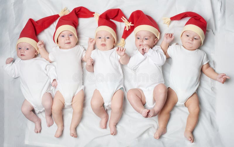 Babies with santa hats on bright background stock photography Babies with santa hats on bright background stock photography