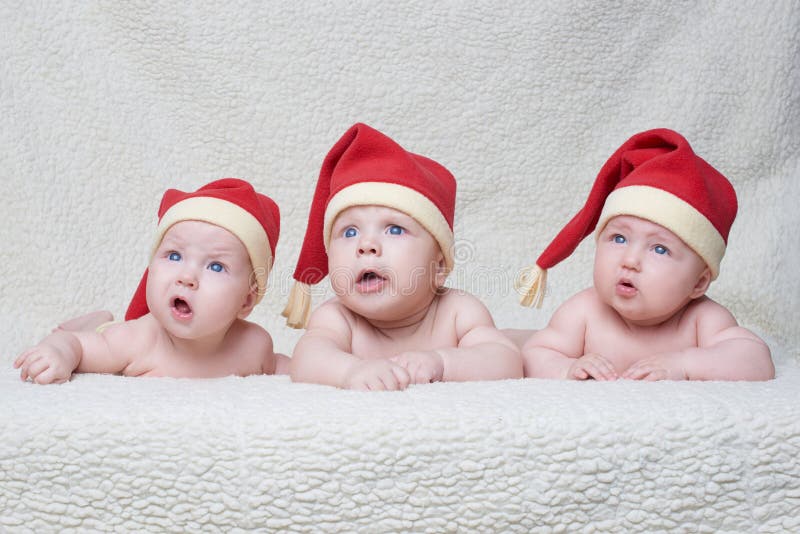 Babies with santa hats on bright background stock photo Babies with santa hats on bright background stock photo