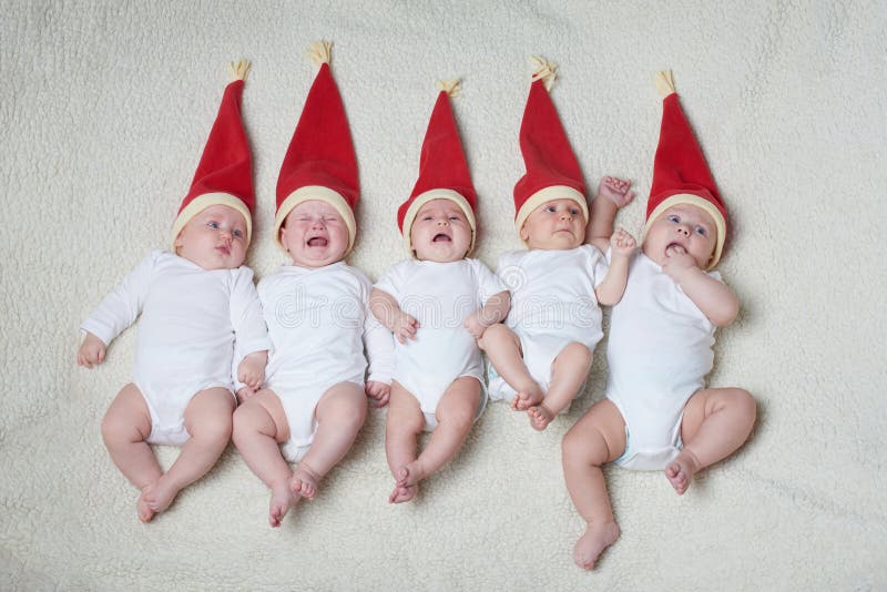 Babies with santa hats on bright background stock photo Babies with santa hats on bright background stock photo