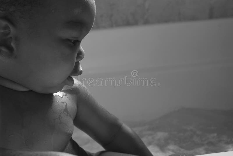 Questo bambino è guardando le bolle di reso da idromassaggio.