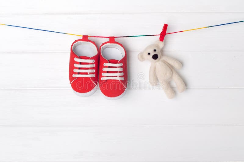 Baby booties and bear toy on clothespins
