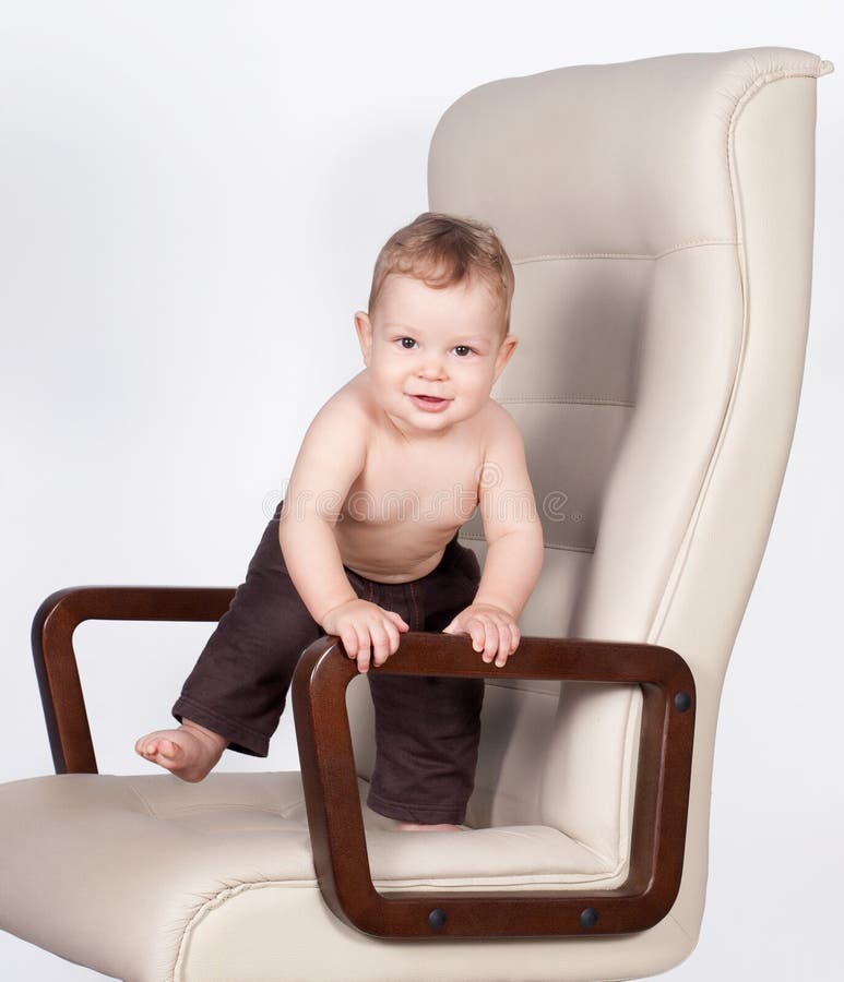 Baby Standing Up Against a Chair Isolated on White Stock Photo Image