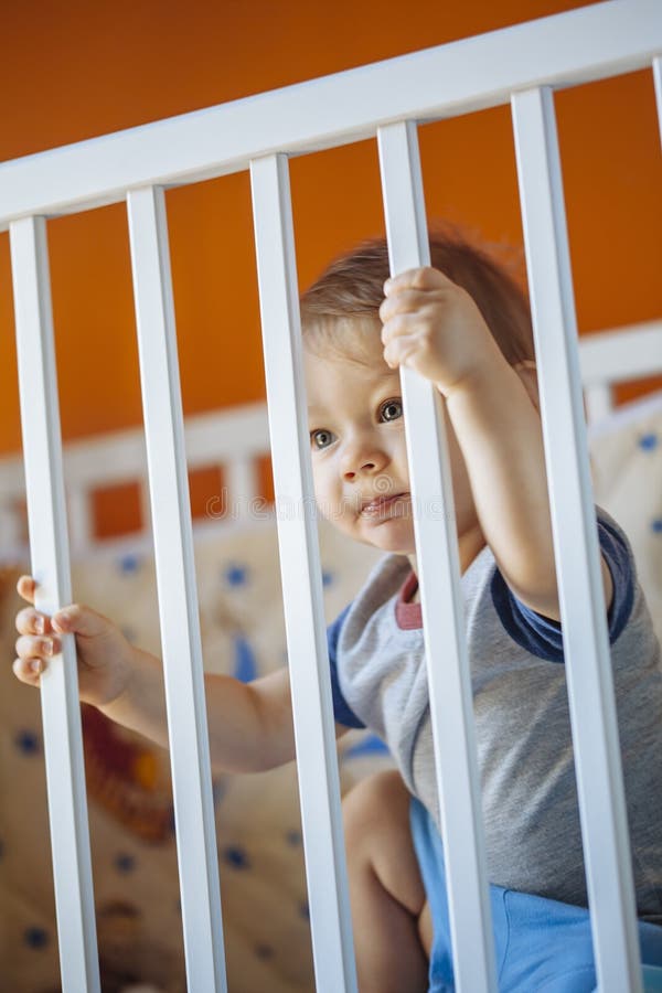 Baby Boy in a Crib stock image. Image of curious, carefree 59229383