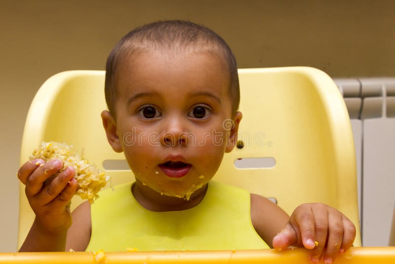 Cheerful happy baby child eats itself with a spoon stock photography Cheerful happy baby child eats itself with a spoon stock photography