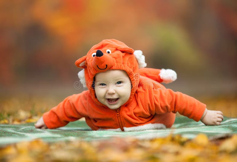 Baby boy dressed in fox costume in autumn park