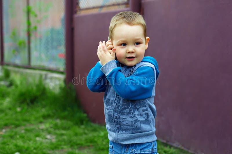 Baby boy emulate talking on the phone