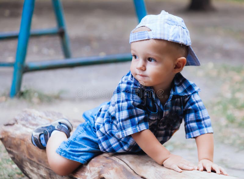 Baby boy lying on a log