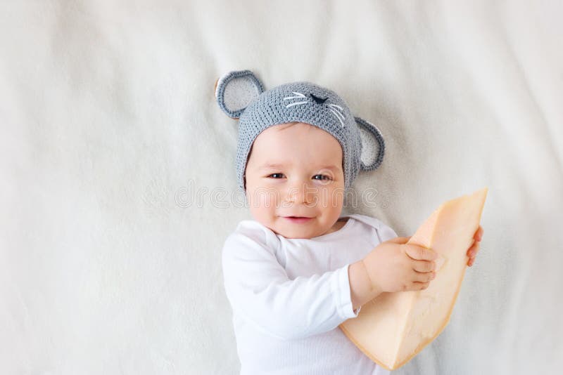 Baby boy in mouse hat lying on blanket with cheese stock photography Baby boy in mouse hat lying on blanket with cheese stock photography