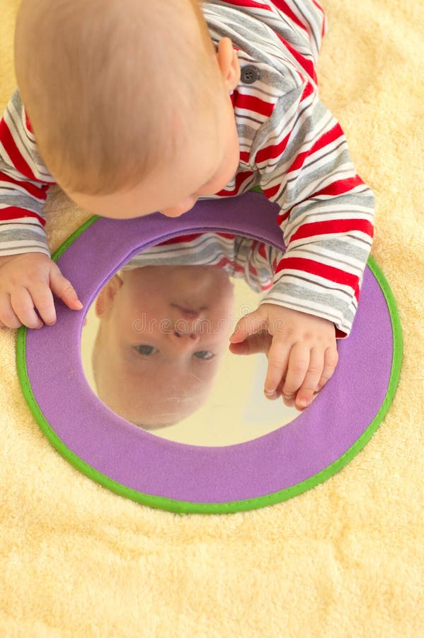 Baby boy plays with mirror