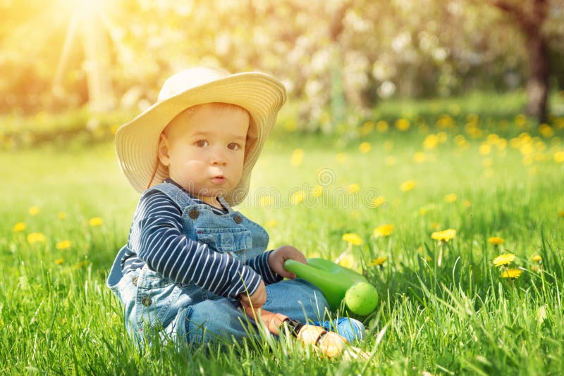 Baby boy sitting on the grass with dandelion flowers in the garden stock photos Baby boy sitting on the grass with dandelion flowers in the garden stock photos