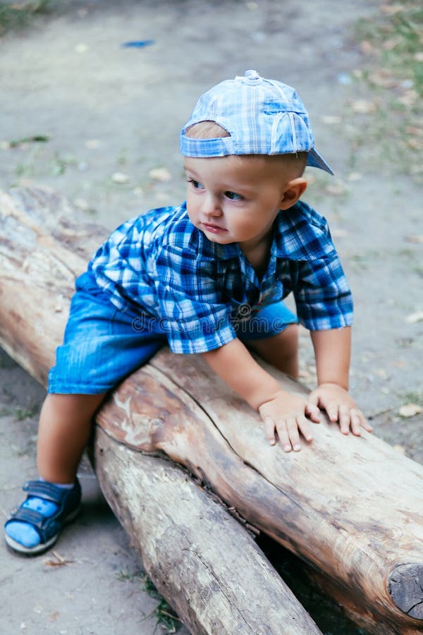 Baby boy sitting on a log