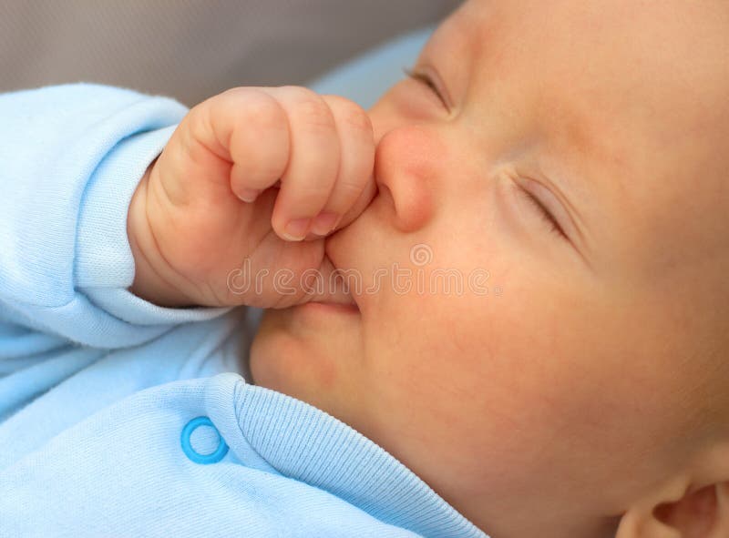 Baby boy sucking thumb to fall asleep