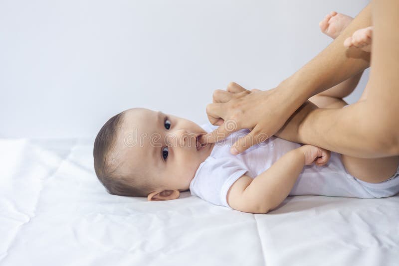 Baby boy teething pain. Little 6-month baby having teeth pains. Mother rubbing gel to her little baby boy`s teeth royalty free stock images Baby boy teething pain. Little 6-month baby having teeth pains. Mother rubbing gel to her little baby boy`s teeth royalty free stock images