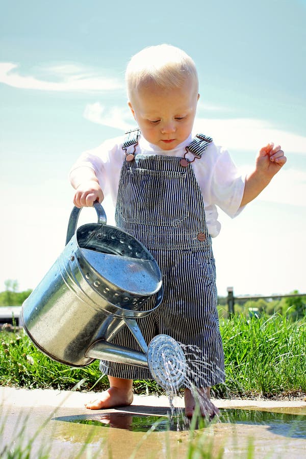 Baby Boy with Watering Can stock photo. Image of conductor 31296498