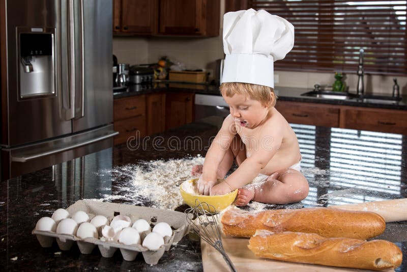 Baby-Bäcker Sitting in der Küche stockbild Baby-Bäcker Sitting in der Küche stockbild