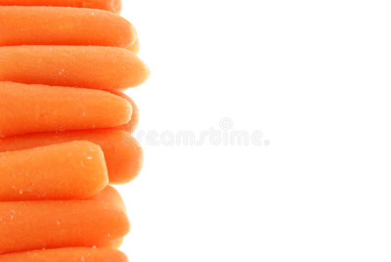 Baby carrots lined up along the side of a white background to create a border, frame or background. Baby carrots lined up along the side of a white background to create a border, frame or background