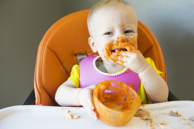 Baby, das mit Lebensmittel auf Gesicht isst