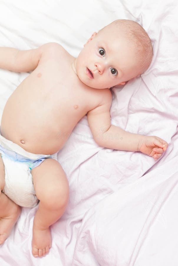 Baby in diaper laying on the bed