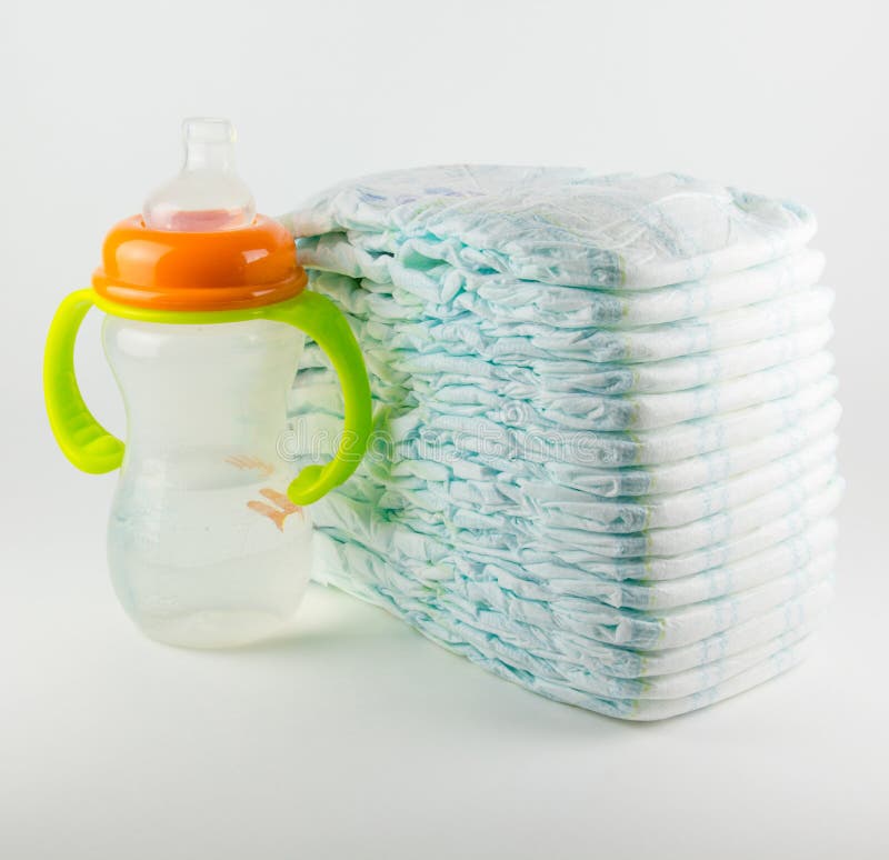 Baby diapers and bottle on a white background stock image Baby diapers and bottle on a white background stock image