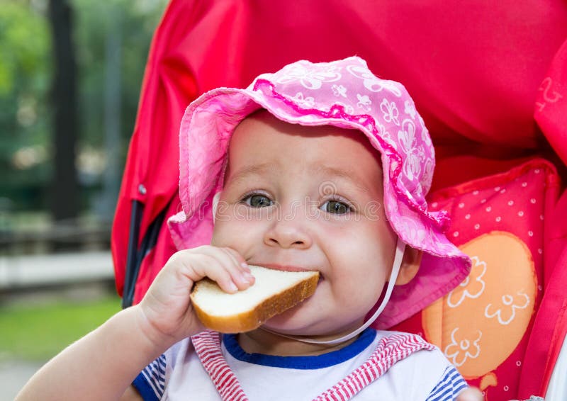 Baby die een stuk van brood eten stock fotografie Baby die een stuk van brood eten stock fotografie