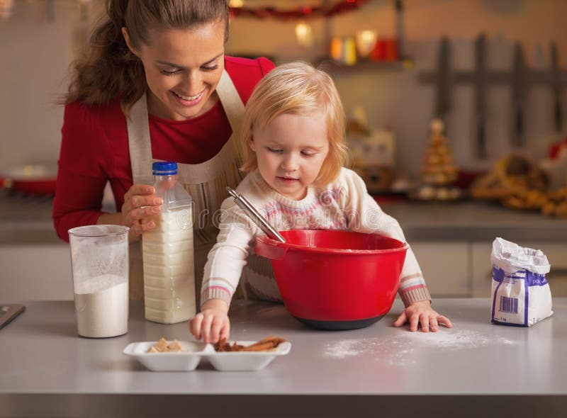 Baby die moeder helpen Kerstmiskoekjes in keuken maken stock foto Baby die moeder helpen Kerstmiskoekjes in keuken maken stock foto