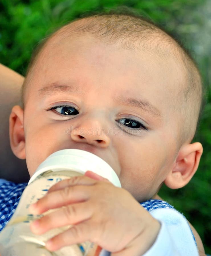 Baby drinking from bottle stock image. Image of cuddling 29638931