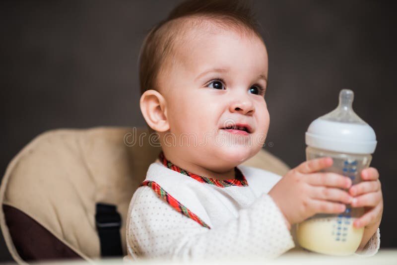 Baby Drinking Milk from a Bottle in the Apartment Stock Photo Image