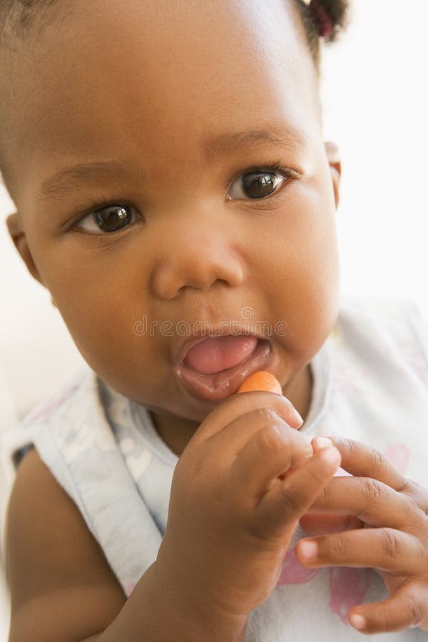 Baby eating carrot