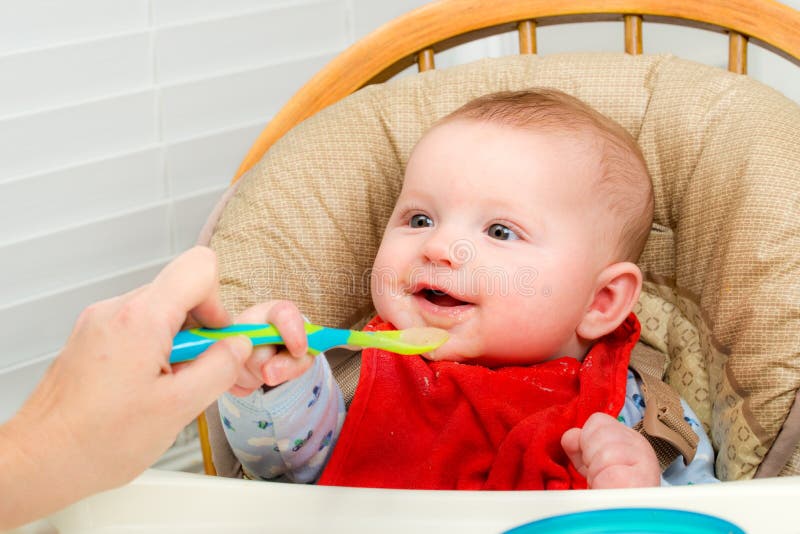 Baby eating homemade organic pureed food