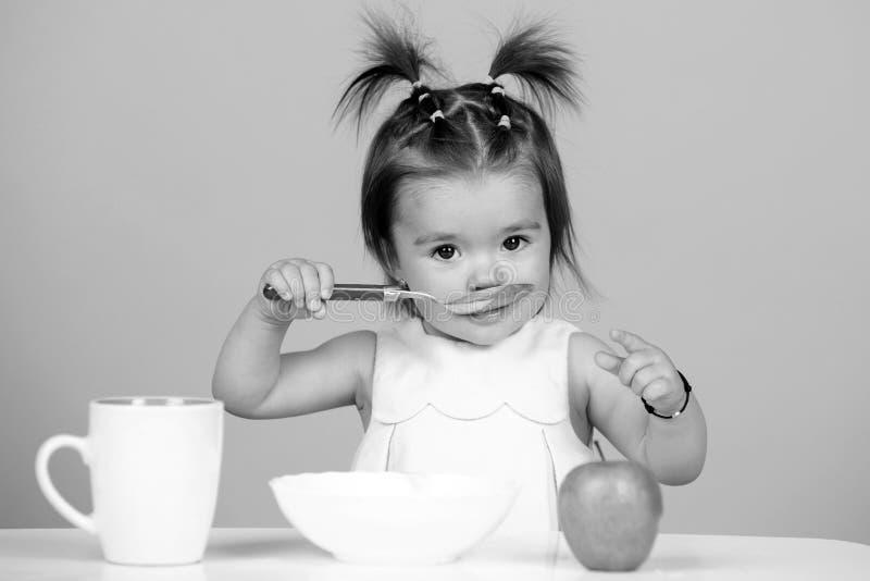 Baby Eating Kids Food Kid Eating Healthy Food With A Spoon At Studio Isolated Funny Kids Face baby-eating-kids-food-kid-eating-healthy-food-with-a-spoon-at-studio-isolated-funny-kids-face