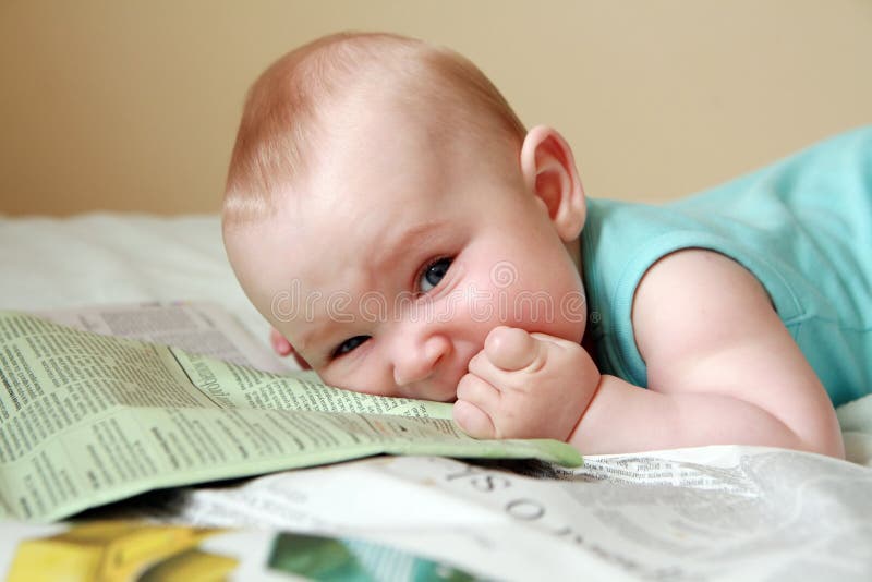 Baby eating newspaper