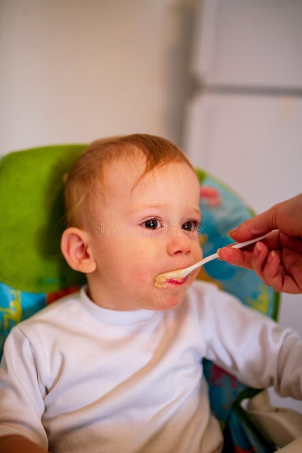 Baby enjoys when eating food in kitchen stock images Baby enjoys when eating food in kitchen stock images