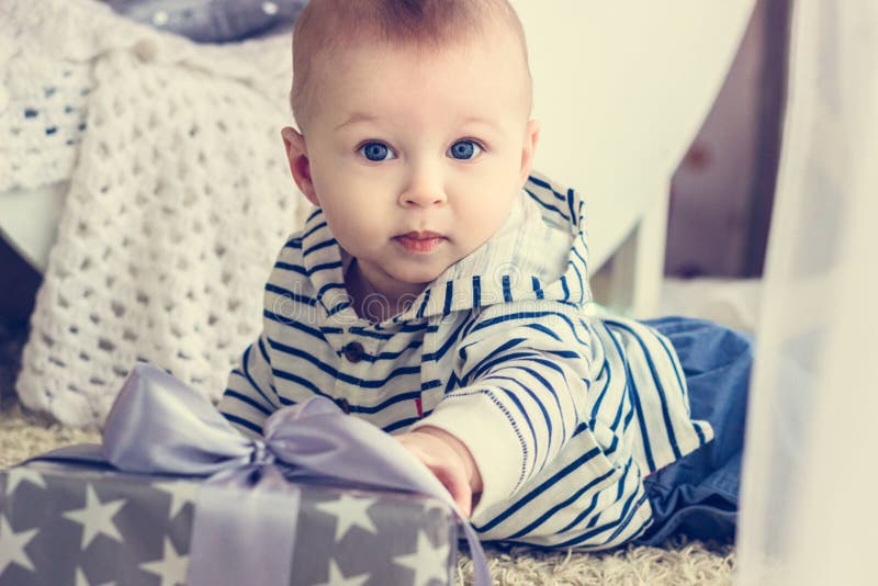 Baby erreicht zu seinem Geschenk lizenzfreie stockfotografie Baby erreicht zu seinem Geschenk lizenzfreie stockfotografie