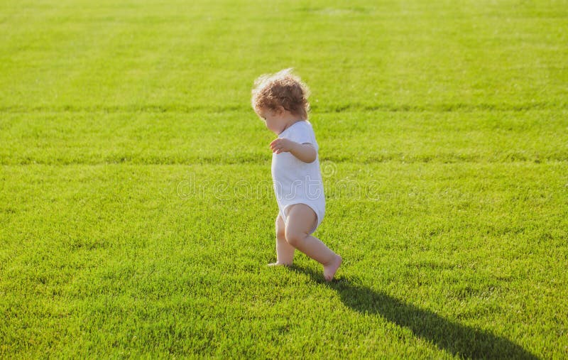 Baby Feet on the Green Grass. First Step. Stock Photo Image of family