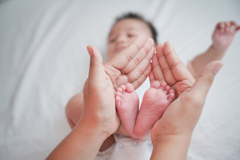 Baby feet in mother hands. Mom and her child. Happy family concept. Beautiful conceptual image of maternity, Newborn baby feet stock image Baby feet in mother hands. Mom and her child. Happy family concept. Beautiful conceptual image of maternity, Newborn baby feet stock image