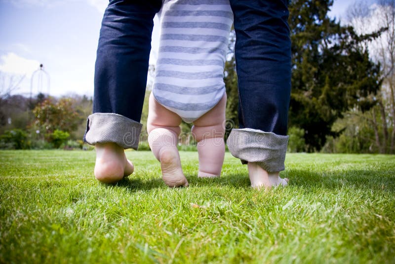 Baby giovani a parlare dei suoi primi passi nel giardino con l'aiuto di suo padre.