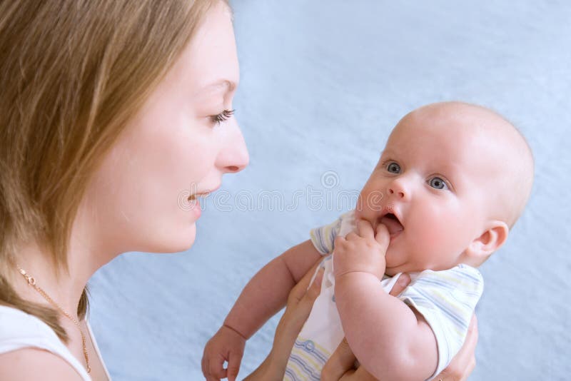 Baby of five months old in his mothers hands.