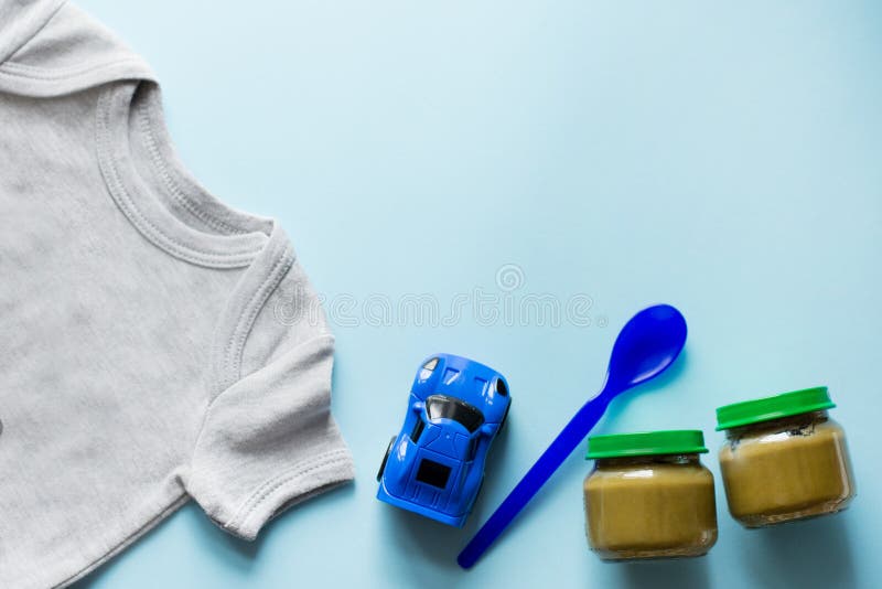 Baby flat lay with toy, healthy food and cloth , blue background with copy space royalty free stock photo Baby flat lay with toy, healthy food and cloth , blue background with copy space royalty free stock photo
