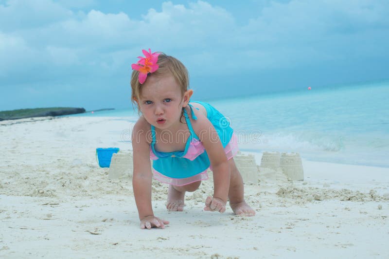 A baby girl on the beach stock photography