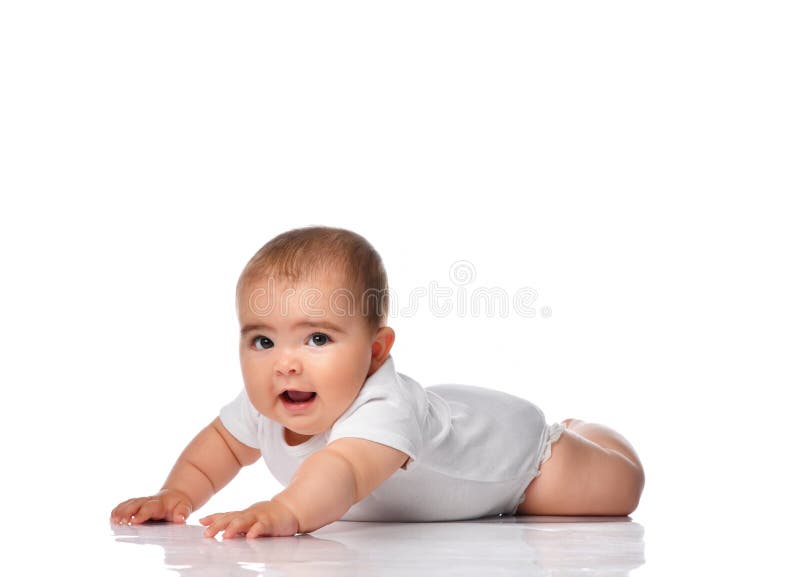Beautiful little baby, crawling isolated on white background. Baby girl crawls in a bodysuit on a white background. The child lies on the floor and looks at the stock image Beautiful little baby, crawling isolated on white background. Baby girl crawls in a bodysuit on a white background. The child lies on the floor and looks at the stock image