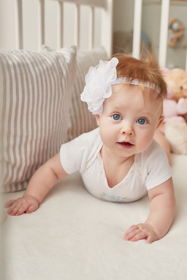 Baby girl in a crib with toys