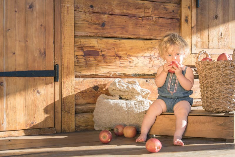 Baby Girl eating apple on a farm