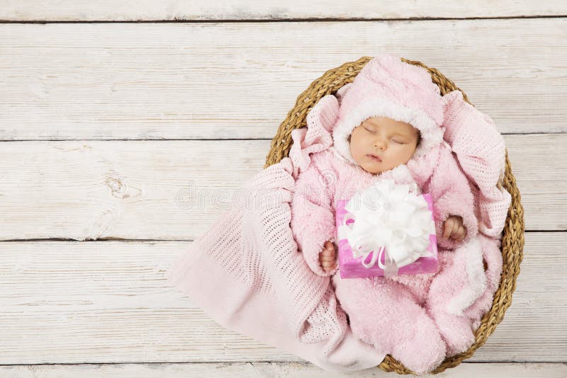 Baby girl with gift sleeping on wooden background, newborn in ba stock photos Baby girl with gift sleeping on wooden background, newborn in ba stock photos