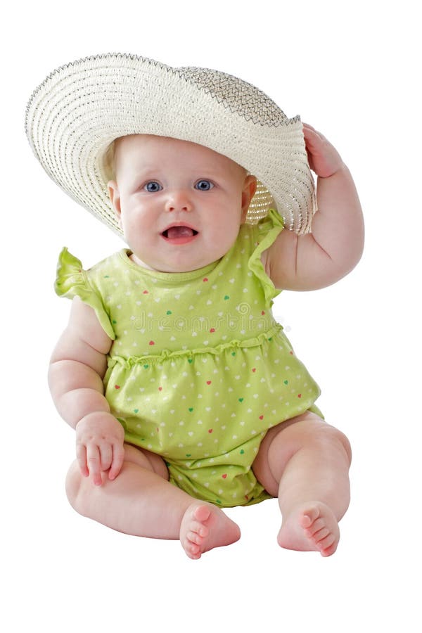 Baby girl in green dress sits wearing big straw hat