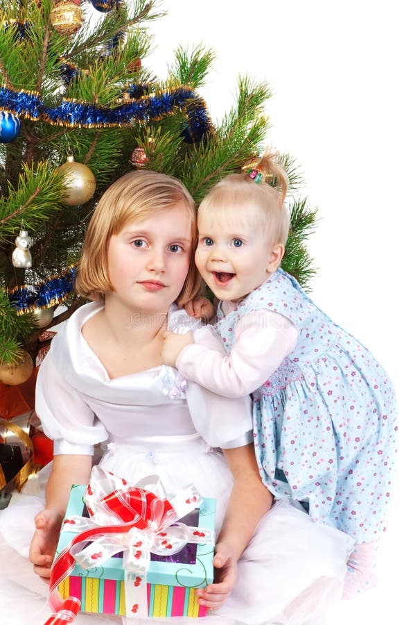 Baby girl hugging her sister under the christmas t stock photography Baby girl hugging her sister under the christmas t stock photography